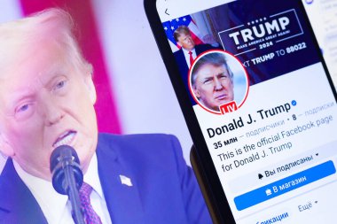 20 Ocak 2025. Ukrayna. Polta. 2025 'in açılış törenini laptop ekranında, ön planda Trump Facebook profilini akıllı telefon ekranında. Yumuşak odak.