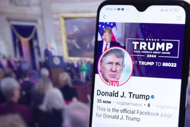 20 Ocak 2025. Ukrayna. Polta. 2025 'in açılış törenini laptop ekranında, ön planda Trump Facebook profilini akıllı telefon ekranında. Yumuşak odak.