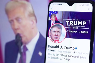 20 Ocak 2025. Ukrayna. Polta. 2025 'in açılış törenini laptop ekranında, ön planda Trump Facebook profilini akıllı telefon ekranında. Yumuşak odak.