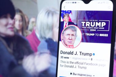 20 Ocak 2025. Ukrayna. Polta. 2025 'in açılış törenini laptop ekranında, ön planda Trump Facebook profilini akıllı telefon ekranında. Yumuşak odak.