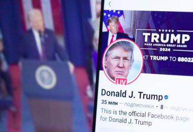 20 Ocak 2025. Ukrayna. Polta. 2025 'in açılış törenini laptop ekranında, ön planda Trump Facebook profilini akıllı telefon ekranında. Yumuşak odak.