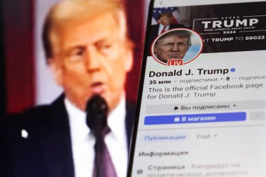 20 Ocak 2025. Ukrayna. Polta. 2025 'in açılış törenini laptop ekranında, ön planda Trump Facebook profilini akıllı telefon ekranında. Yumuşak odak.