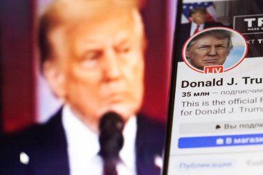 20 Ocak 2025. Ukrayna. Polta. 2025 'in açılış törenini laptop ekranında, ön planda Trump Facebook profilini akıllı telefon ekranında. Yumuşak odak.