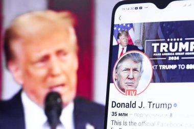 20 Ocak 2025. Ukrayna. Polta. 2025 'in açılış törenini laptop ekranında, ön planda Trump Facebook profilini akıllı telefon ekranında. Yumuşak odak.