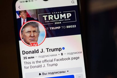 20 Ocak 2025. Ukrayna. Polta. 2025 'in açılış törenini laptop ekranında, ön planda Trump Facebook profilini akıllı telefon ekranında. Yumuşak odak.