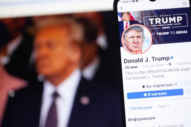 20 Ocak 2025. Ukrayna. Polta. 2025 'in açılış törenini laptop ekranında, ön planda Trump Facebook profilini akıllı telefon ekranında. Yumuşak odak.