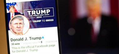 20 Ocak 2025. Ukrayna. Polta. 2025 'in açılış törenini laptop ekranında, ön planda Trump Facebook profilini akıllı telefon ekranında. Yumuşak odak.