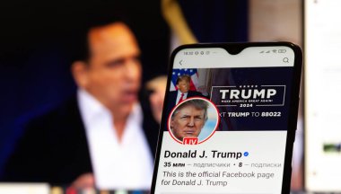 20 Ocak 2025. Ukrayna. Polta. 2025 'in açılış törenini laptop ekranında, ön planda Trump Facebook profilini akıllı telefon ekranında. Yumuşak odak.