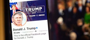 20 Ocak 2025. Ukrayna. Polta. 2025 'in açılış törenini laptop ekranında, ön planda Trump Facebook profilini akıllı telefon ekranında. Yumuşak odak.