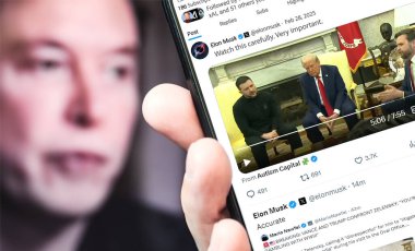 Poltava, Ukrayna - 28 Şubat 2025. Elon Musk Twitter profili sayfasında elinde akıllı telefonuyla yeni bir tweet var. Arka planda Elon Musk 'un odaksız bir portresi var..