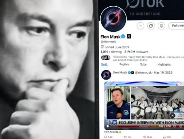 Poltava, Ukrayna - 19 Mart 2025. Elon Musk Twitter profili sayfasında elinde akıllı telefonuyla yeni bir tweet var. Arka planda Elon Musk 'un odaksız bir portresi var..