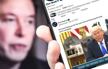 Poltava, Ukrayna - 22 Mart 2025. Elon Musk Twitter profili sayfasında elinde akıllı telefonuyla yeni bir tweet var. Arka planda Elon Musk 'un odaksız bir portresi var..