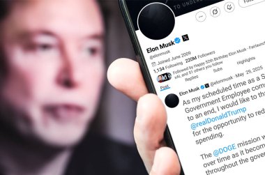 Bernkastel-Kues, Almanya - 29 Mayıs 2025: Elon Musk Twitter profili sayfasında elinde akıllı telefonuyla yeni bir tweet var. Arka planda Elon Musk 'un odaksız bir portresi var..