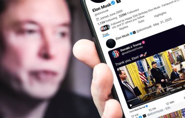Bernkastel-Kues, Almanya - 31 Mayıs 2025: Elon Musk Twitter profili sayfası ve yeni bir akıllı telefon tweeti. Arka planda Elon Musk 'un odaksız bir portresi var..