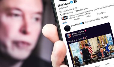 Bernkastel-Kues, Almanya - 31 Mayıs 2025: Elon Musk Twitter profili sayfası ve yeni bir akıllı telefon tweeti. Arka planda Elon Musk 'un odaksız bir portresi var..