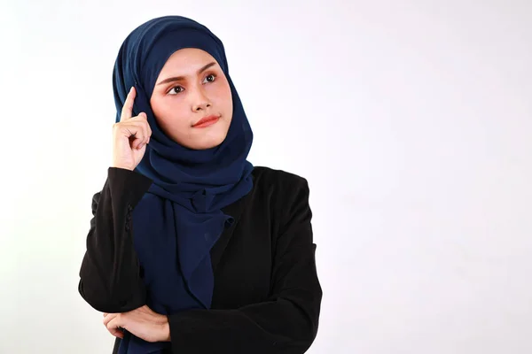 身穿穆斯林服装的聪明的亚洲女商人站在那里 用姿势 思维和对工作室的信心来触摸头 带头巾的漂亮脸蛋的孤立的白色背景肖像 — 图库照片