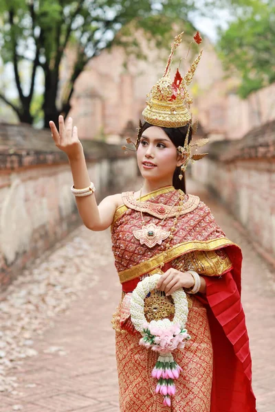 タイの赤い伝統衣装を着た若いファッションと美しいアジアの女性は タイの古代寺院Ayutthayaで幸せと平和立って屋外でジャスミンの花のガーランドを保持しています 旅行のコンセプト — ストック写真