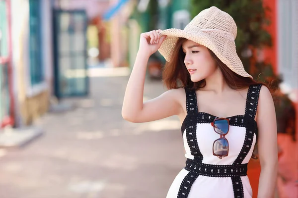 年轻的亚洲美丽的黑发女子带着帽子在旅游胜地摆姿势 穿着时髦衣服站在城市街道上的漂亮女模特的户外肖像 城市户外旅行的概念 — 图库照片
