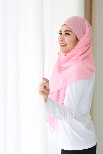 Όμορφη Ασιάτισσα Που Φοράει Λευκά Μουσουλμανικά Ρούχα Στέκεται Στο Παράθυρο — Φωτογραφία Αρχείου