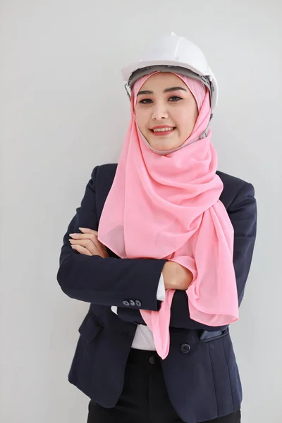 スタジオで自信を持って笑顔青いイスラム教徒のスーツを着て美しいエンジニアの若いアジアの女性 ピンクのヒジャーブと美しい顔の女の子と隔離された白い背景の肖像画 広告ポートレートのコンセプト — ストック写真