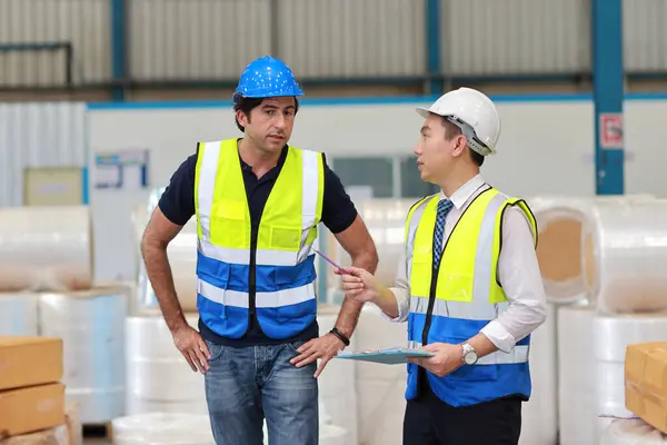 stock image Architect or engineering men and worker standing and checking large warehouse with clipboard. Multiethnic two business manager controlling work at warehouse industry building. 