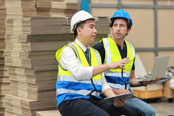 建築家やエンジニアの男性と労働者が立って タブレットで大きな倉庫をチェックします 倉庫業界の建物で作業を管理する多民族2人のビジネスマネージャー — ストック写真