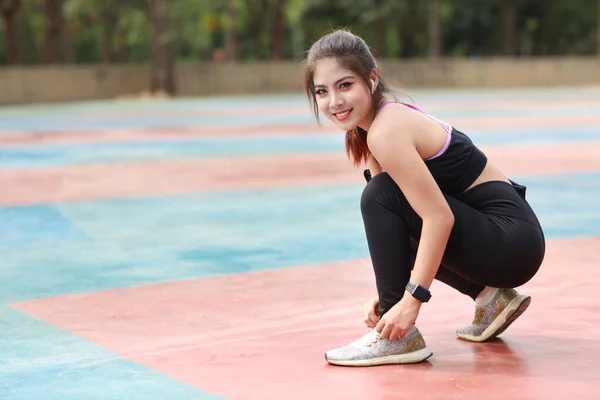 スリムな運動脚でスポーツウェアジョギング屋外での美しいアジアの女性の肖像画 スポーティーな女の子の手が休憩と靴を結ぶ ワークアウトの後 健康的でライフスタイルのアウトドアコンセプト — ストック写真