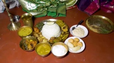 Bengali öğle yemeği pirinç tabaklar ve kaselerde çeşitli sebzeler ve kızarmış balıklarla servis edilir. Bu tabaklar yerde oturarak yenir ve Hindistan ve Bangladeş 'in popüler besin maddelerinin bir parçasıdır..