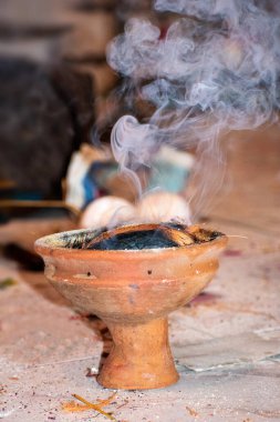 Aarti 'deki puja sırasında kullanılan Dhunuchi olarak bilinen Bengali tütsü yakma fırınının resmi, toprak malzemesinden yapılmış, tabanda yanan kömür tutmak için dizayn edilmiş, yavaş yanan hindistan cevizi kabuğunu tutuşturmak için, genellikle Hint tütsüsü ile birlikte kullanılır.