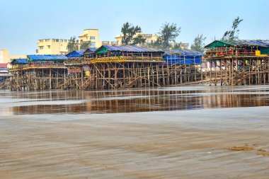 This picture depicts the scenic Mandarmani beach in the Bay of Bengal near Digha, India, where several beautiful, lofty bars cum restaurants can be seen on the seashore, made of bamboo, wood, and tarpaulin. clipart