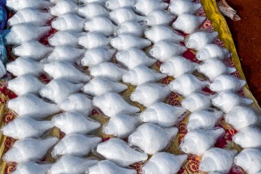 Bu resimde güzelce oyulmuş beyaz deniz kabukları güzelce plastiğe sarılmış. Yerel dilde onlara Shankha deniyor. Geleneksel işçilik ve kültürel çekiciliği vurguluyor..