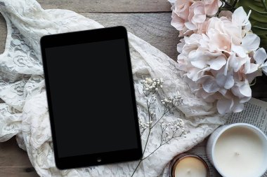 Rahat bir okuma konsepti için bir ahır ahşap masa üstü arka planında gri bir eşarp, bir fincan sıcak çikolata ve tablet ile rahat bir düz yatıyordu.