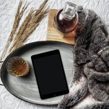 Yaşam tarzı düz kompozisyon ve yatak konseptinde okumak için modern tablet pc ile viski ve buğdayın yanı sıra