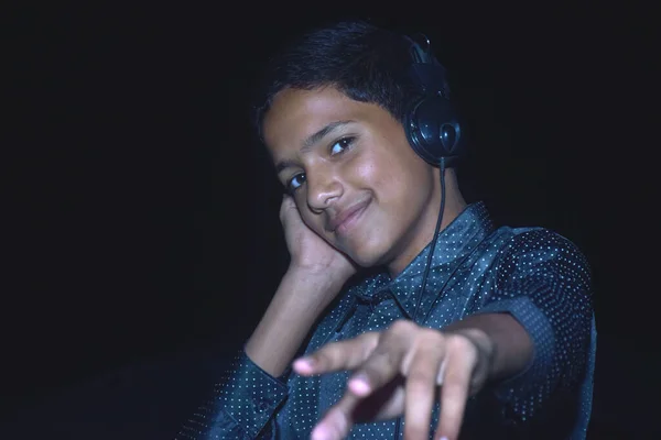 Indian cute boy listening music and enjoy. with black background. music concept