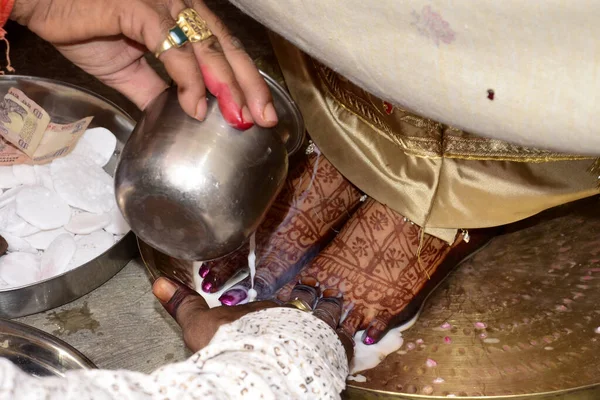 Image of a Hindu bride washing feet during the traditional wedding ceremony