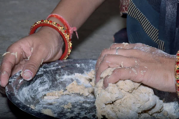 stock image Indian woman hand in dough close-up kneading dough on steel plate, bangles hands