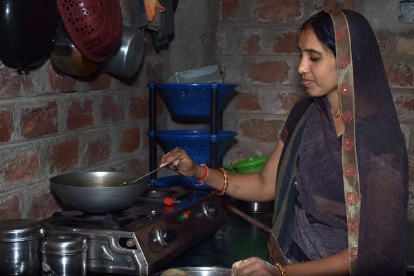 stock image Indian rural housewife cooking food in the kitchen, kitchen concept, brick wall background.