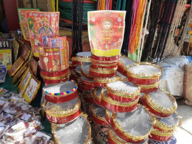 21 Ekim 2021 Dewas, Madhya Pradesh, Hindistan. Hintli bir kadın sokak pazarında toprak tencere ve elek satıyor.