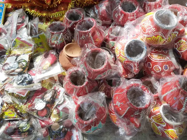 21 Ekim 2021 Dewas, Madhya Pradesh, Hindistan. Hintli bir kadın sokak pazarında toprak tencere ve elek satıyor.