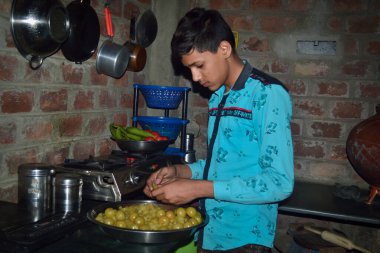 Hintli çocuk bektaşi üzümünden tohumları çıkarıp şeker yapıyor, mutfak konsepti.