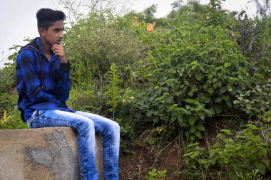 Mavi elbiseli Hintli manken çocuk, yeşillik arka planda..