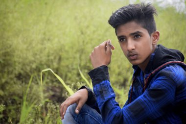 Mavi elbiseli Hintli manken çocuk, yeşillik arka planda..