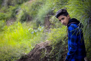 Mavi elbiseli Hintli manken çocuk, yeşillik arka planda..