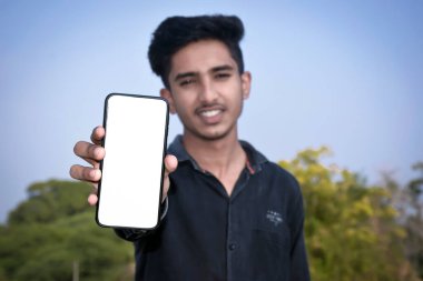 Siyah gömlekli okul çocuğu akıllı bir telefon ekranı gösteriyor. Akıllı telefona odaklan. Kavramsal. Boşluğu kopyala