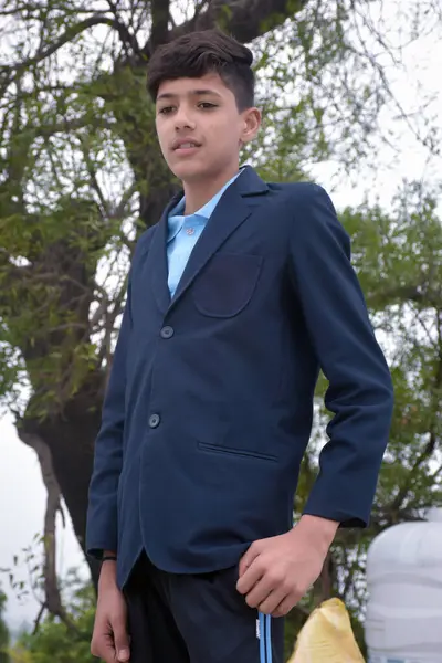 Ayakta duran ve üniformasıyla poz veren bir öğrenci..