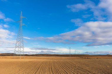 Rüzgâr jeneratörlerinden elektrik taşıyan elektrik kulelerinin metalik yapısı. Gökyüzüne karşı yüksek voltaj kuleleri güç hatları