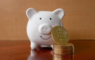 Bitcoins beyaz kumbara ile istiflenmiş. Yatırım tasarruflarında veya kripto döviz yeniliğinde risk ve zenginlik meydana gelebilir