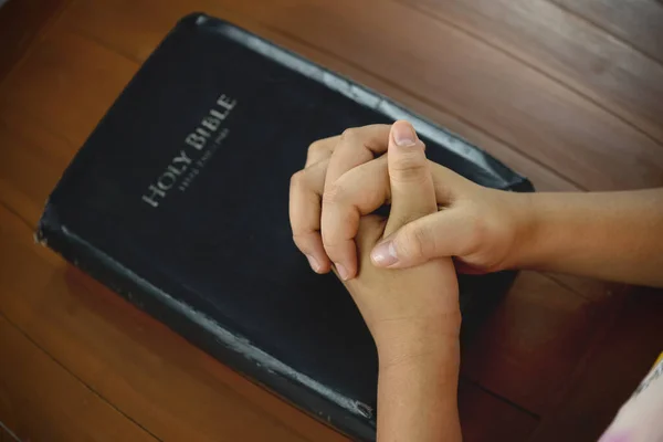 Close-up of Prayer hand with Bible Spiritual book praying, concepts by studying the Holy Scriptures.