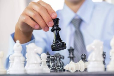 Satrancı kazanmak için strateji ve taktikle hareket ettirir, masa oyununda mücadele eder, iş fırsatı yarışması stratejik meydan okuma konsepti.