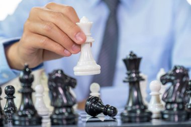 Satrancı kazanmak için strateji ve taktikle hareket ettirir, masa oyununda mücadele eder, iş fırsatı yarışması stratejik meydan okuma konsepti.